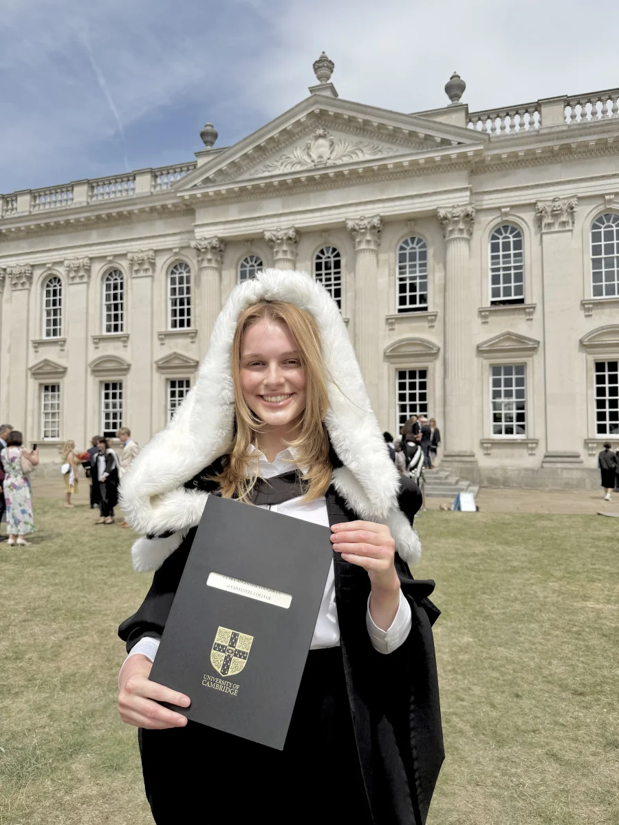 Clara Loughran at her Cambridge graduation, holding her degree certificate